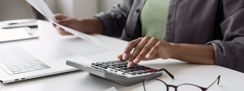 Woman working at desk using a calculator