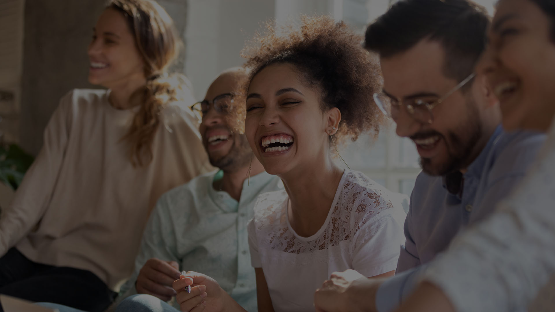 Diverse group of coworkers seated together laughing